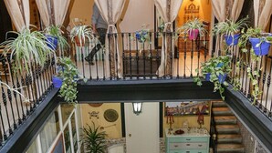 A multi-level interior with a staircase, potted plants, and a dining area. - Pension Internacional (Córdoba)