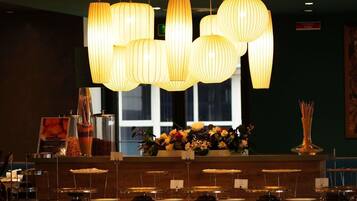 Un espace d’accueil avec un comptoir, des luminaires suspendus et une fenêtre en arrière-plan.