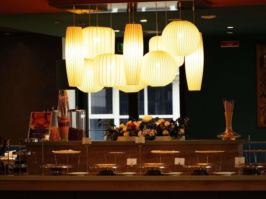 Un espace d’accueil avec un comptoir, des luminaires suspendus et une fenêtre en arrière-plan.