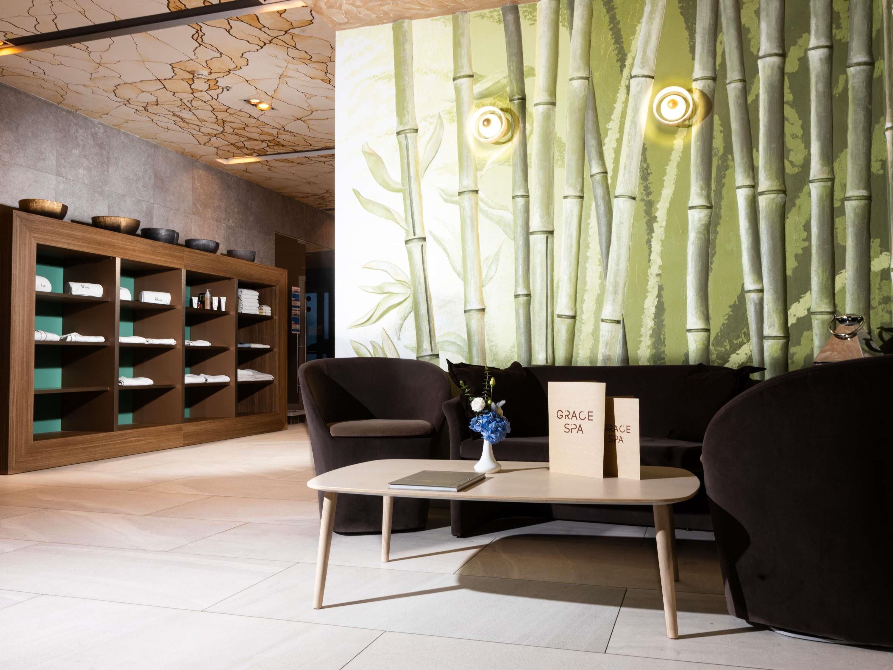 A spa lobby with a bamboo wall, a reception desk, and a seating area.