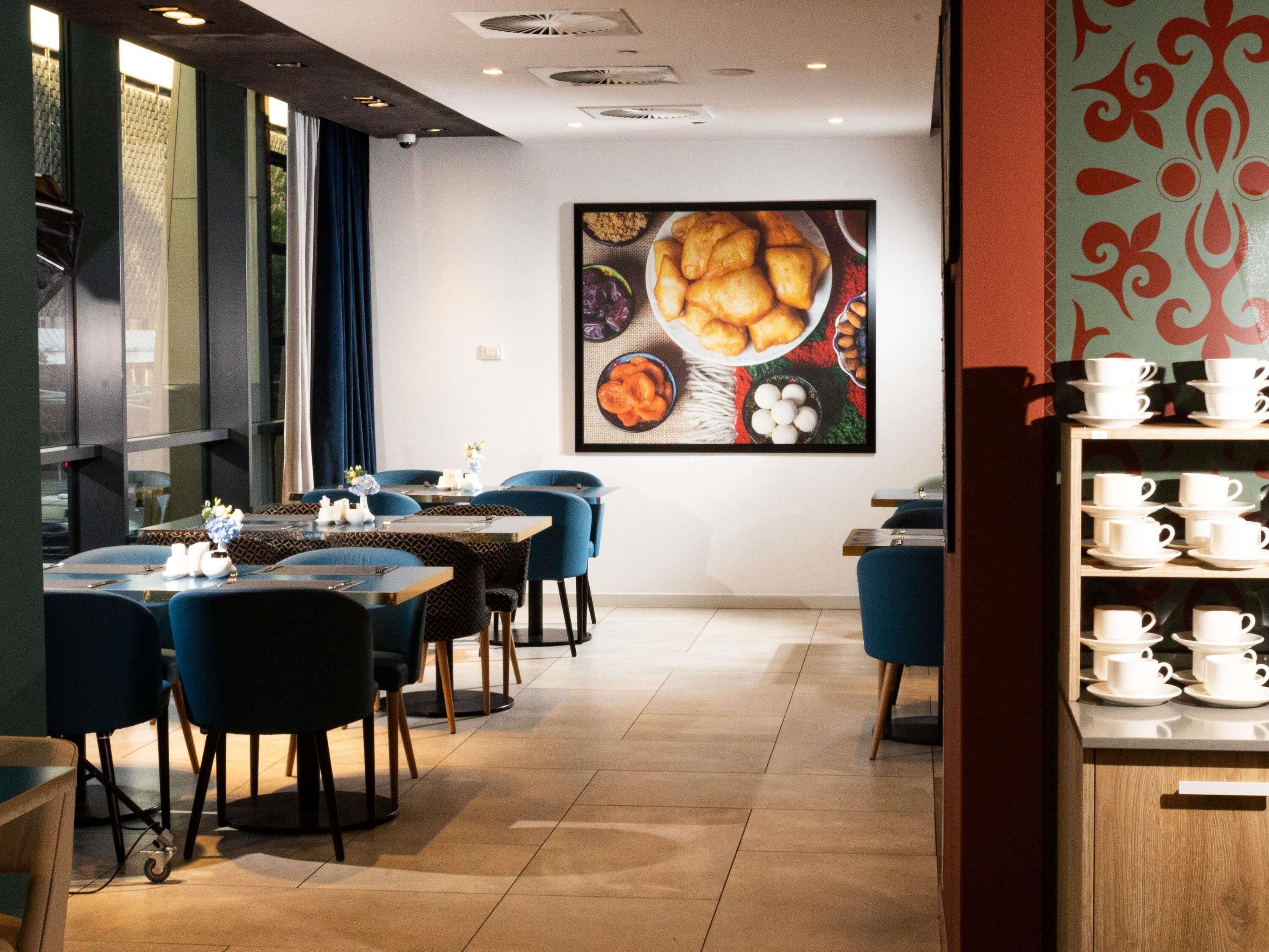 Ein Restaurantinnenraum mit Tischen, Stühlen und einer an der Wand befestigten Speisekarte.