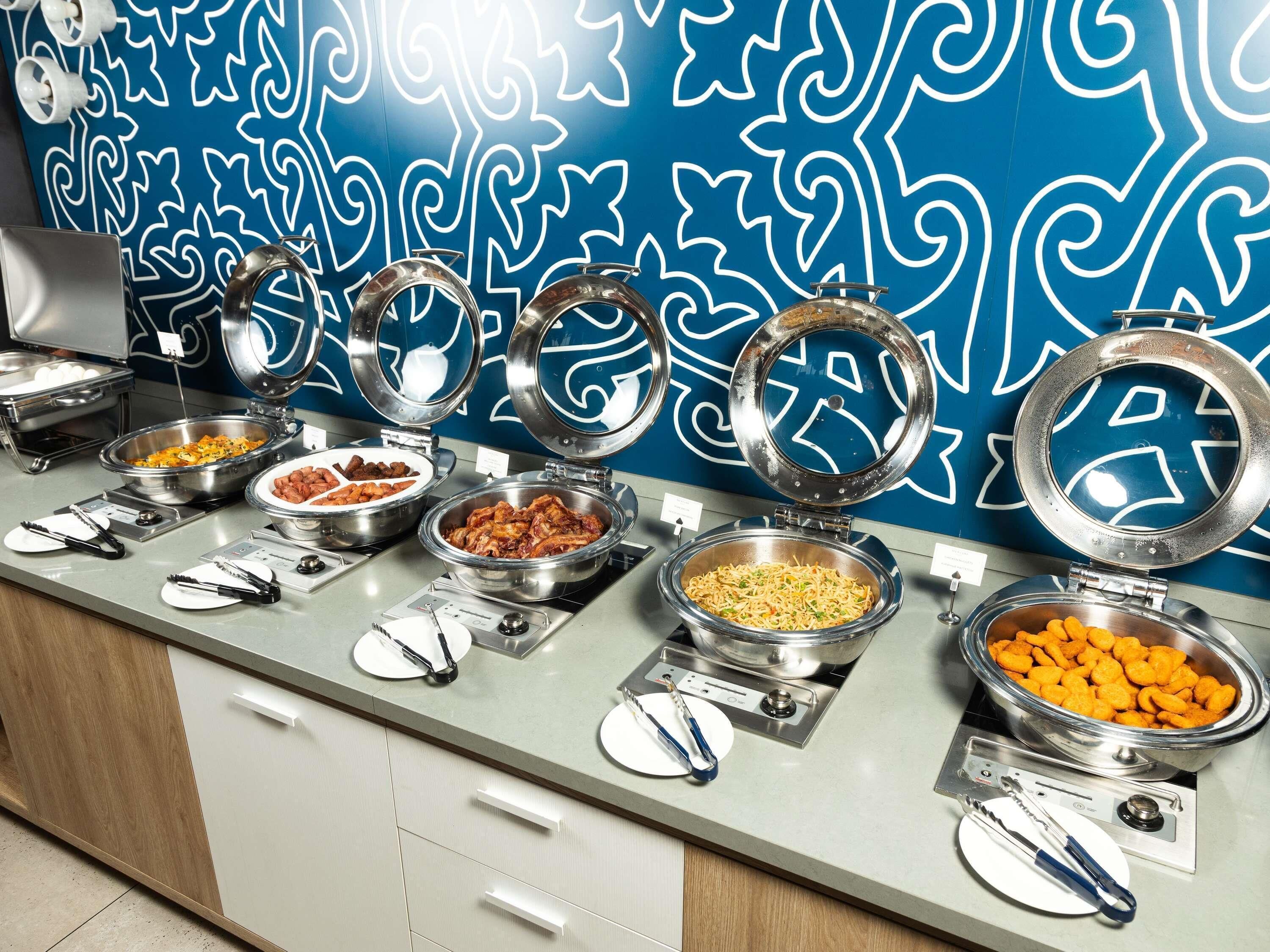 Un buffet avec différents plats présentés dans des bols, une balance et un mur décoratif en arrière-plan.