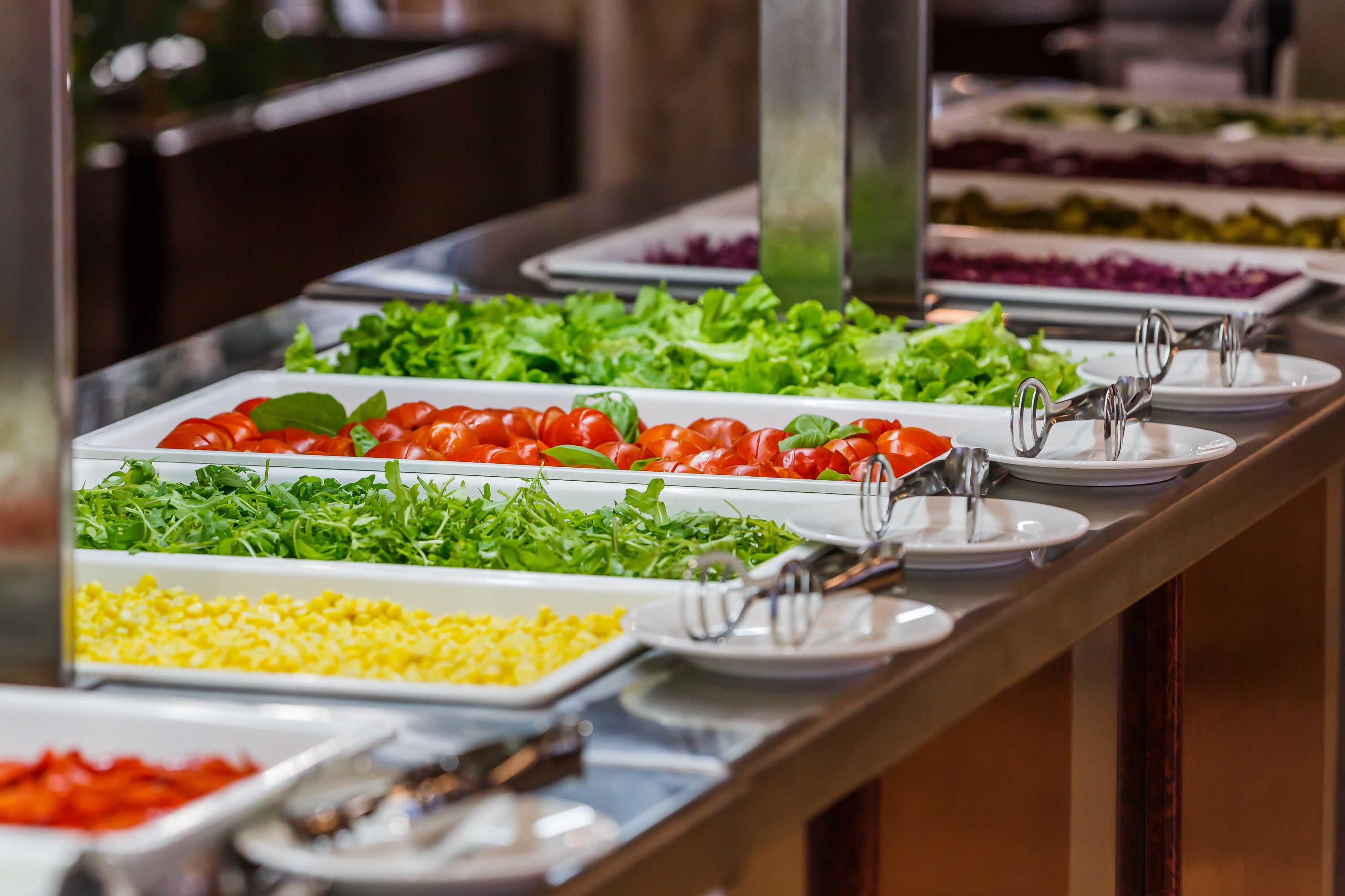 Ein reichhaltiges Buffet mit verschiedenen Speisen, darunter Salate, Tomaten und weitere Gerichte.