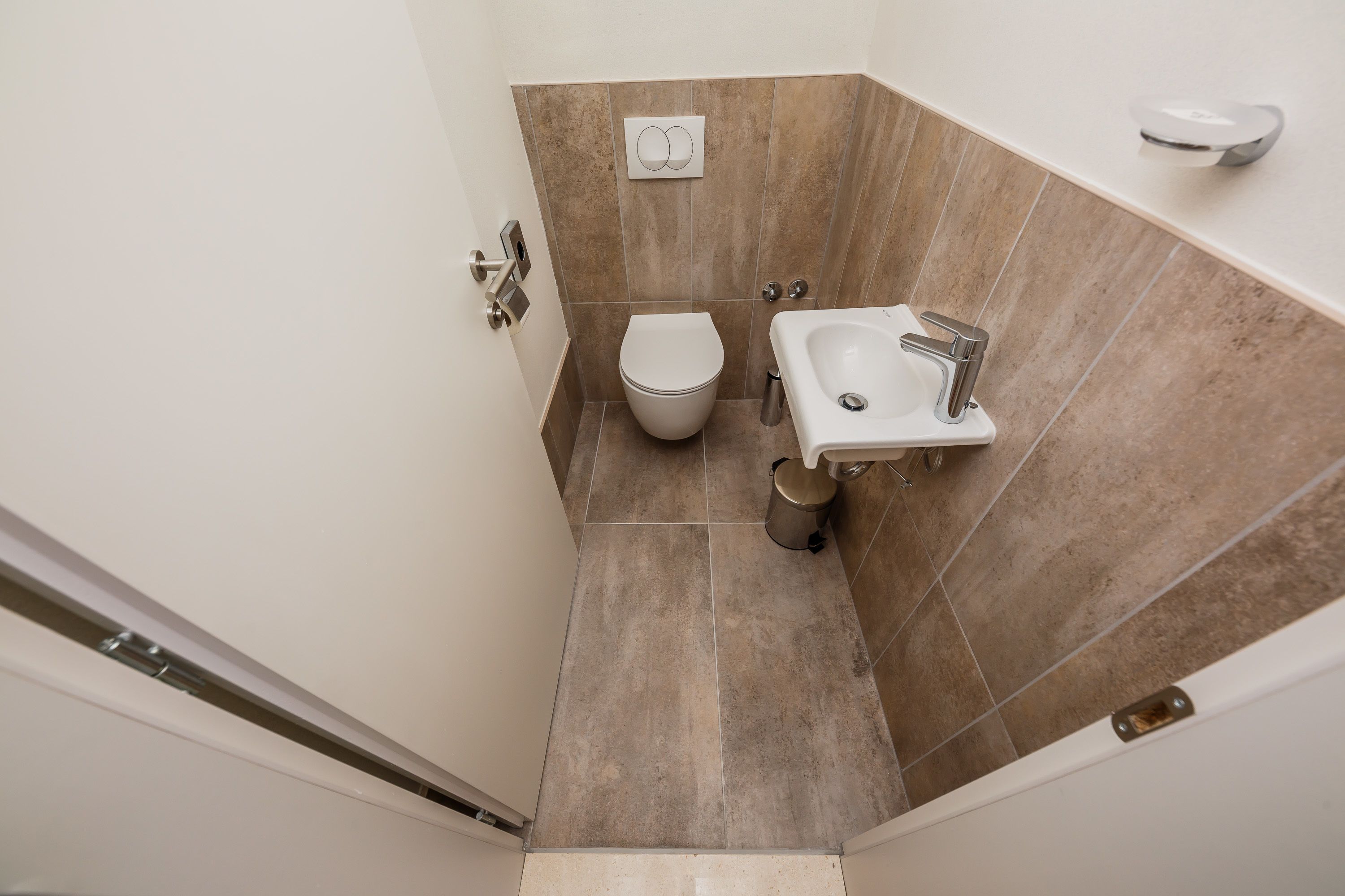 Un baño pequeño con inodoro, lavamanos y cabina de ducha.