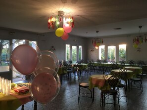 A dining area with tables, chairs, and a chandelier. - Hôtel La Roselière (Saint-Quentin-Fallavier)
