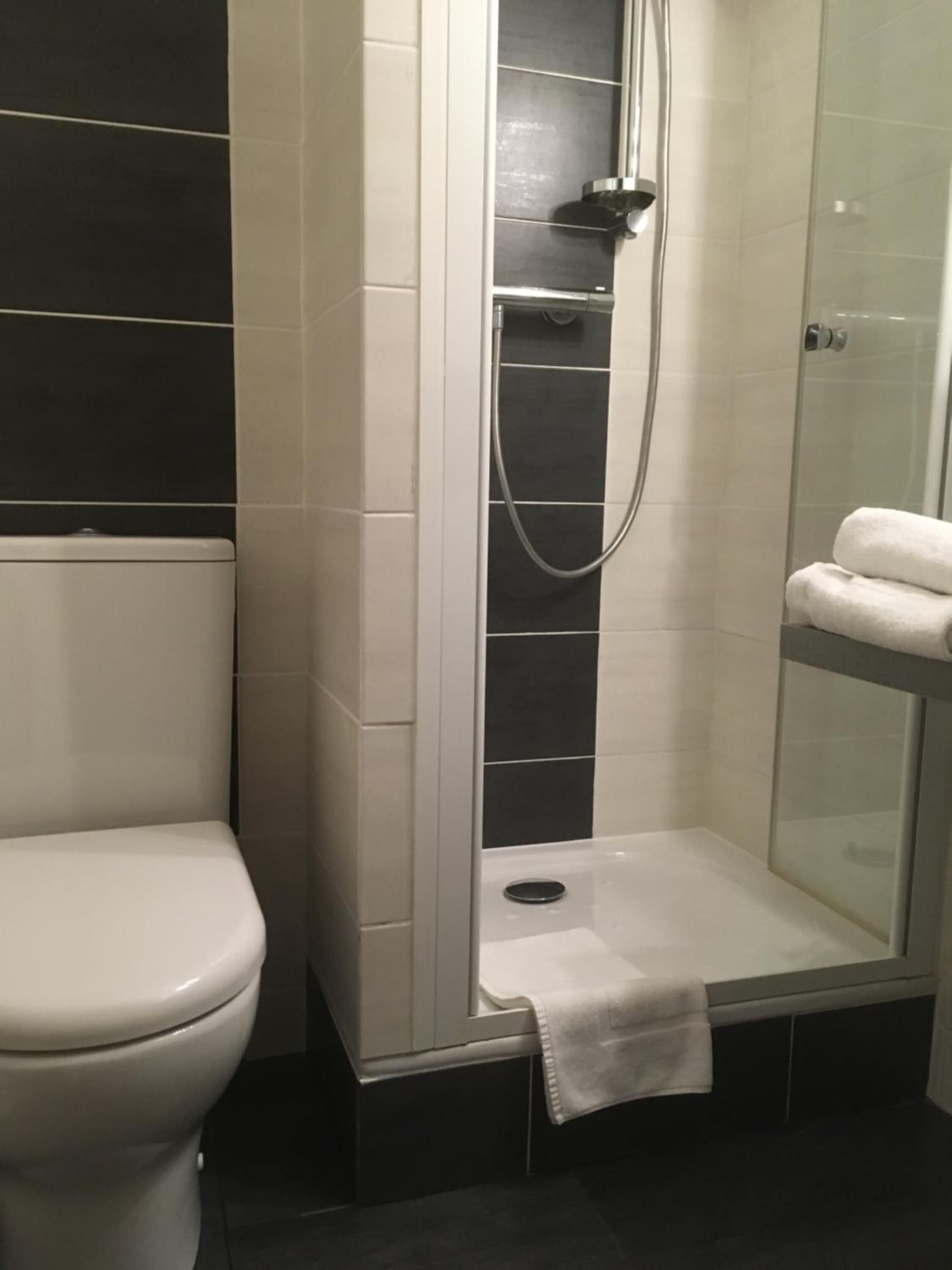 A bathroom with a toilet, a shower enclosure, and a glass shower door.