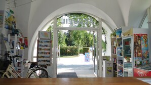 Una librería con una amplia entrada en arco, estanterías y una bicicleta.