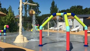 Un área de juegos acuáticos con estructuras de colores y una piscina.