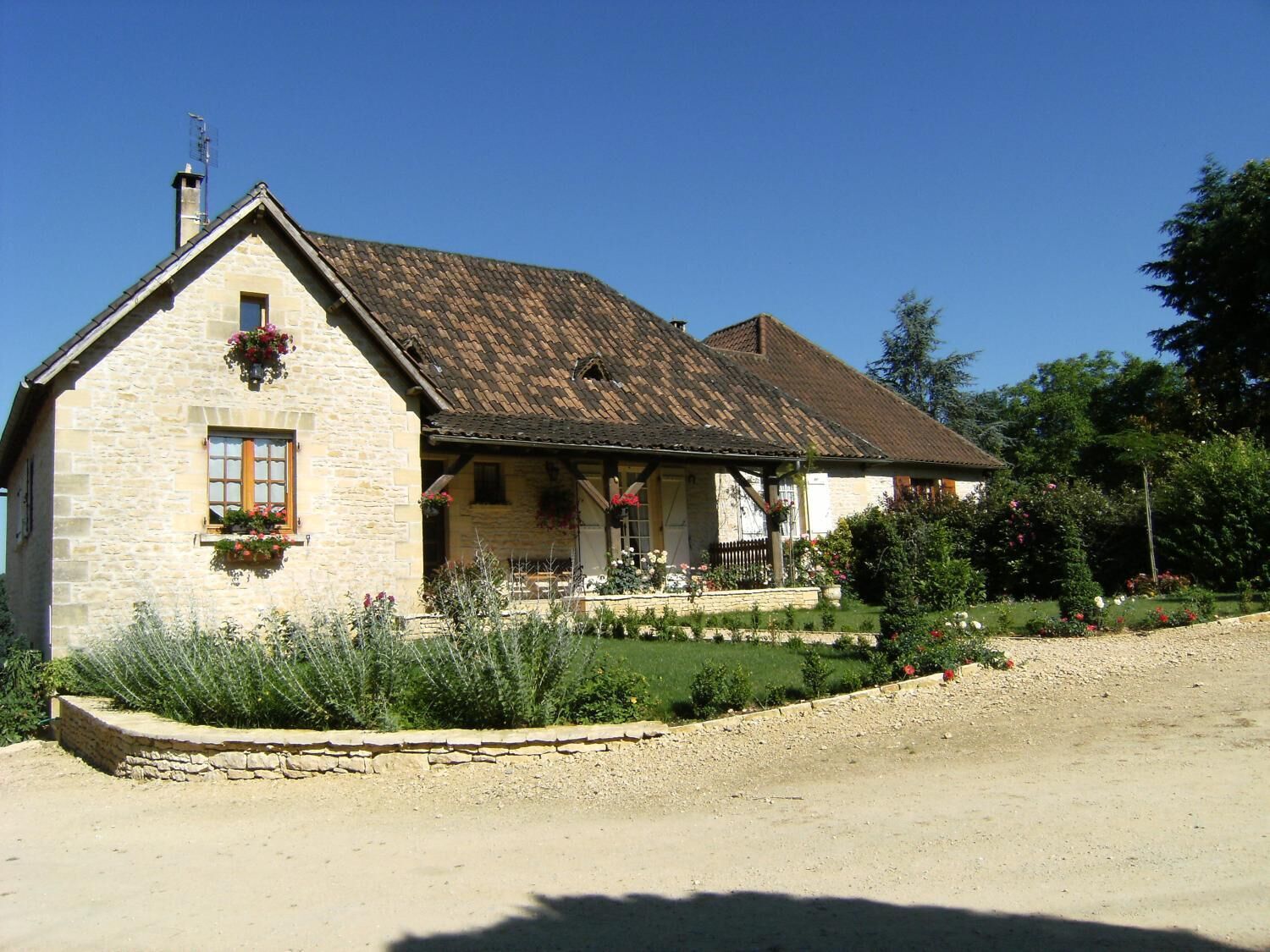 Una casa de piedra con techo inclinado, una puerta de madera y una ventana con contraventanas.