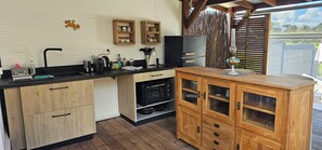 Una cocina con armarios de madera, encimera negra y horno empotrado.