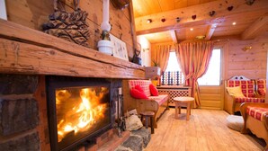 L’intérieur d’un chalet confortable, avec une cheminée, des meubles en bois et une atmosphère chaleureuse.