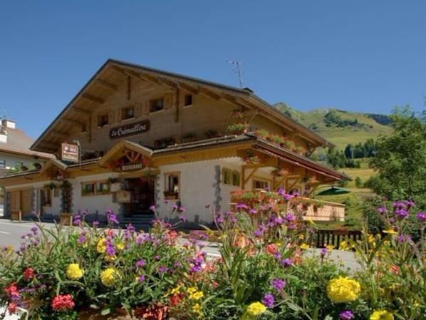 Un bâtiment de style alpin traditionnel, avec une enseigne indiquant qu’il s’agit d’un restaurant.