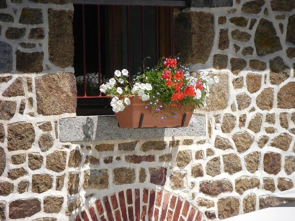 A stone wall with a window and a flower planter. - La Cloue B&B (Lassay-les-Chateaux)