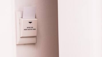 Una puerta con lector de tarjetas que muestra la etiqueta "MIFARE CARD INSERT CARD FOR POWER" y un moderno picaporte.