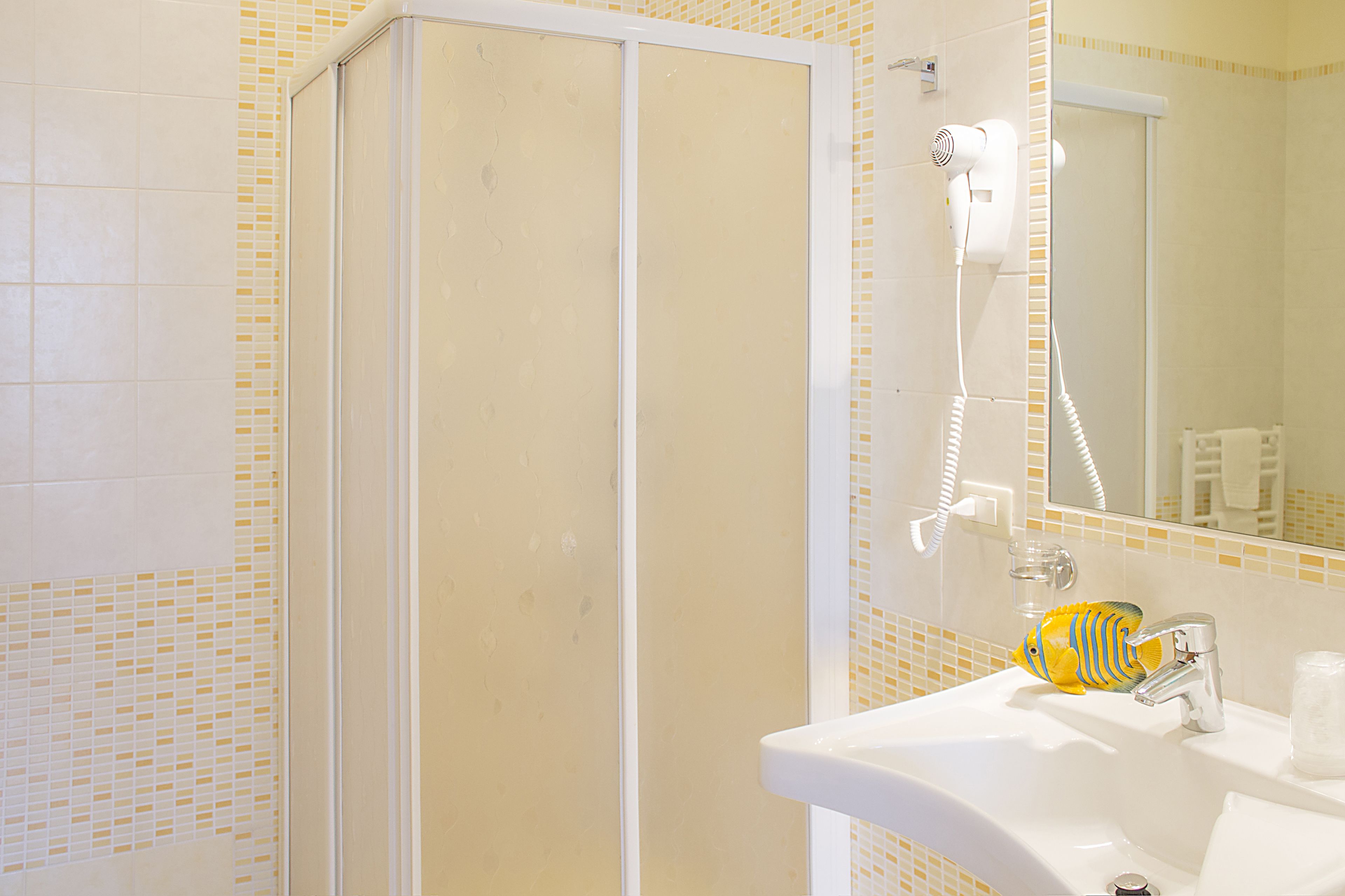 A bathroom with a shower, a sink, and a mirror.