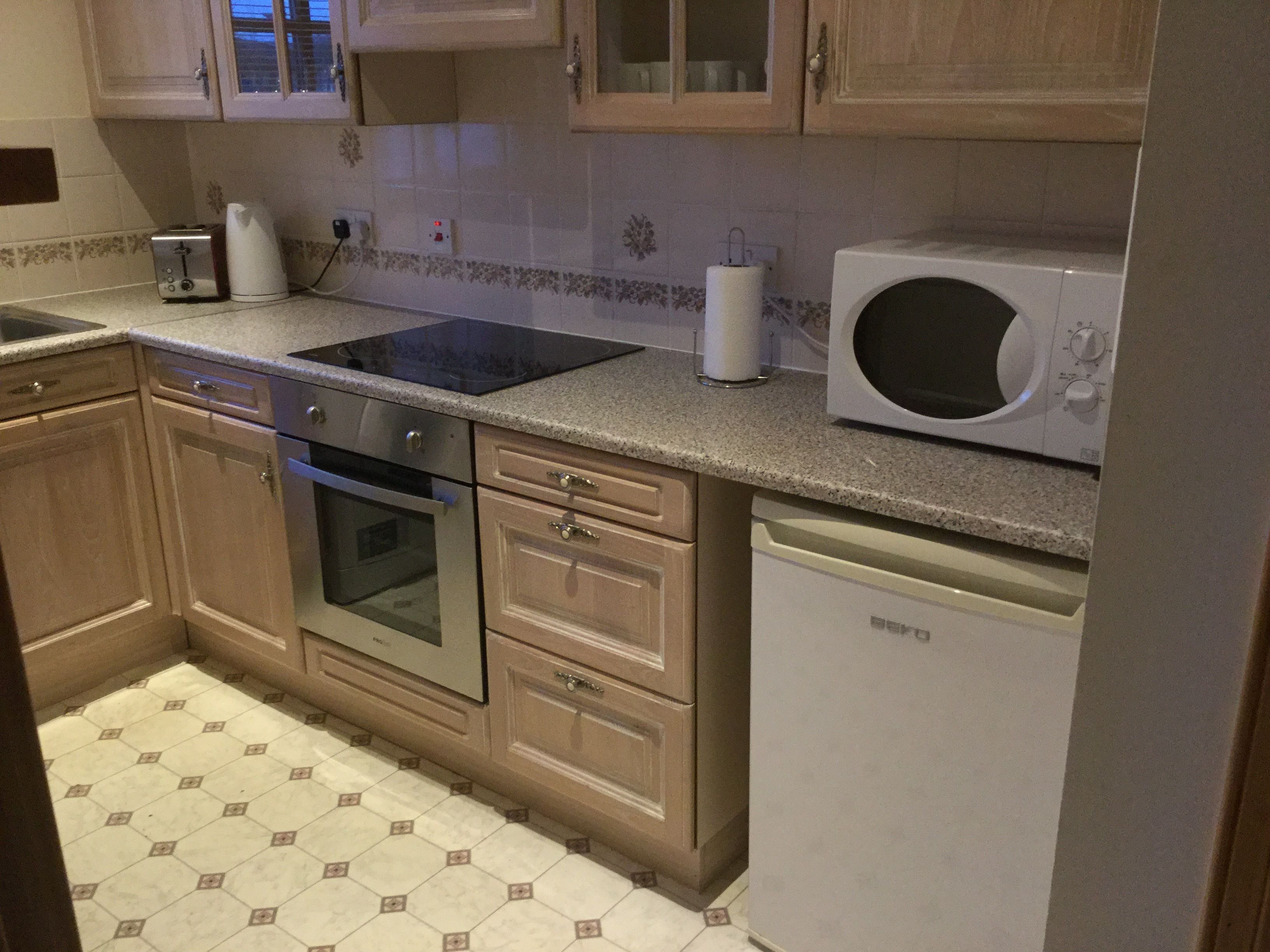Een keuken met een magnetron, broodrooster en oven.