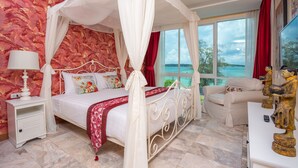 A bedroom with a four-poster bed, a nightstand, a bedside table, a sofa, and a statue. - Almali Rawai Beach Residence (Rawai)