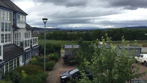 A residential area with a two-story house, a street lamp, and a parked car. - Inverness Apartments - Castlefield (Inverness)
