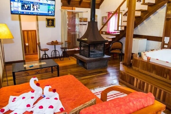 Una habitación acogedora con chimenea, muebles de madera y televisor montado en la pared.