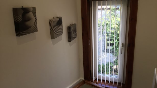 A room with a window with vertical blinds, a wooden frame, and three abstract wall art pieces. - Inverness Apartments - Culduthel (Inverness)