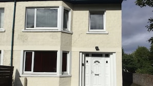 A two-story building with a white exterior, a front door with a number plate, and a small porch area. - Inverness Apartments - Culduthel (Inverness)