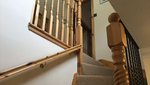 A wooden staircase with a handrail and a carpeted landing. - Inverness Apartments - New Cottage (Inverness)