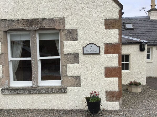 Un edificio con fachada blanca y un cartel que dice "3 The Old Cottage".