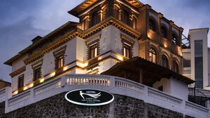 Un hotel amb façana de pedra, diversos balcons i un rètol que indica que és l'Hotel Castillo Vista del Angel.
