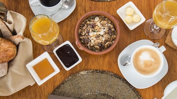 Una escena de desayuno con diferentes alimentos y bebidas sobre una mesa de madera.