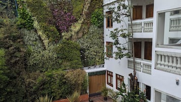 A courtyard with a tiled floor, a covered outdoor table, and potted plants.