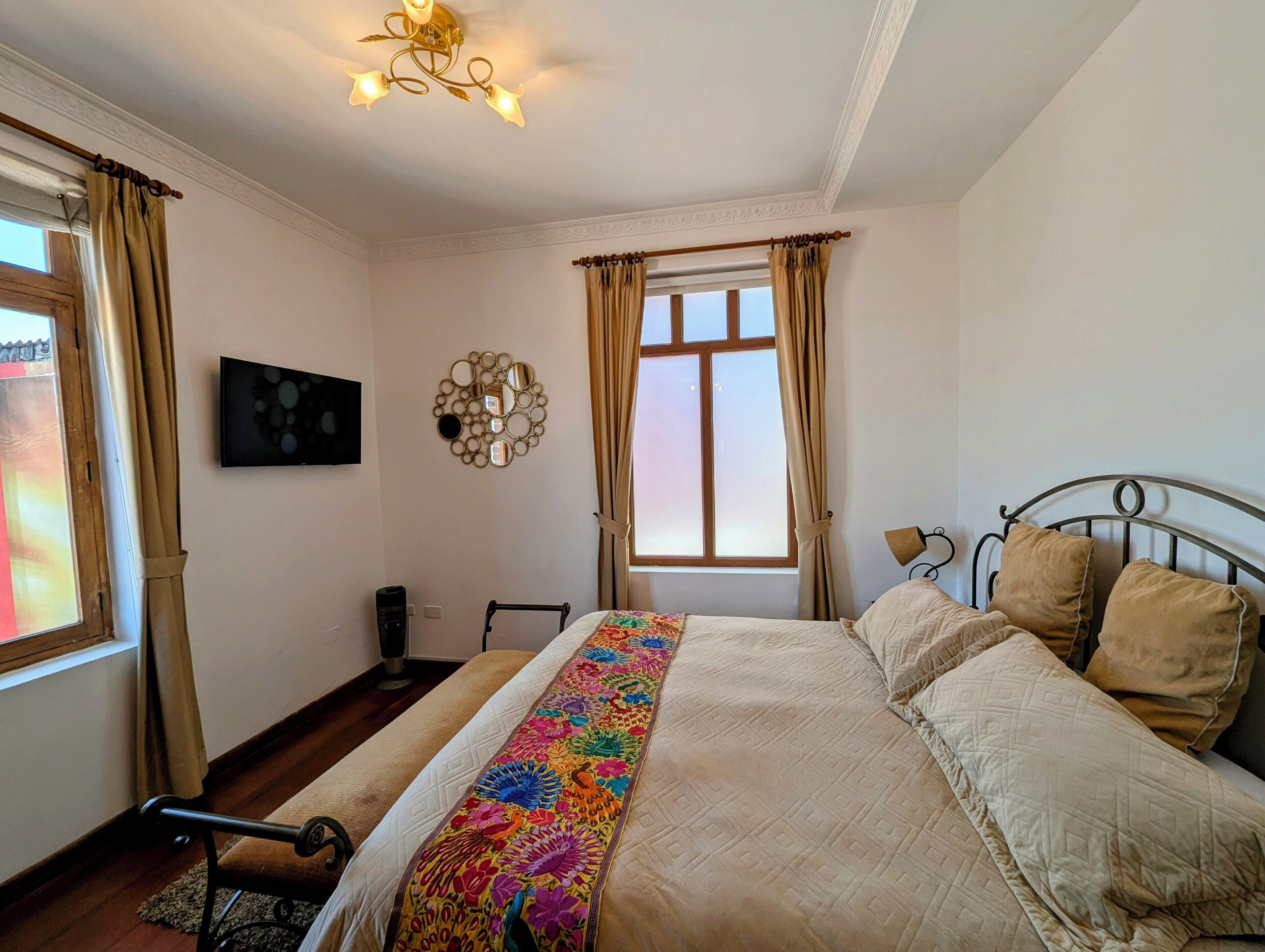 A neatly arranged bedroom with a bed, a bedside table, a lamp, and a wall-mounted TV.