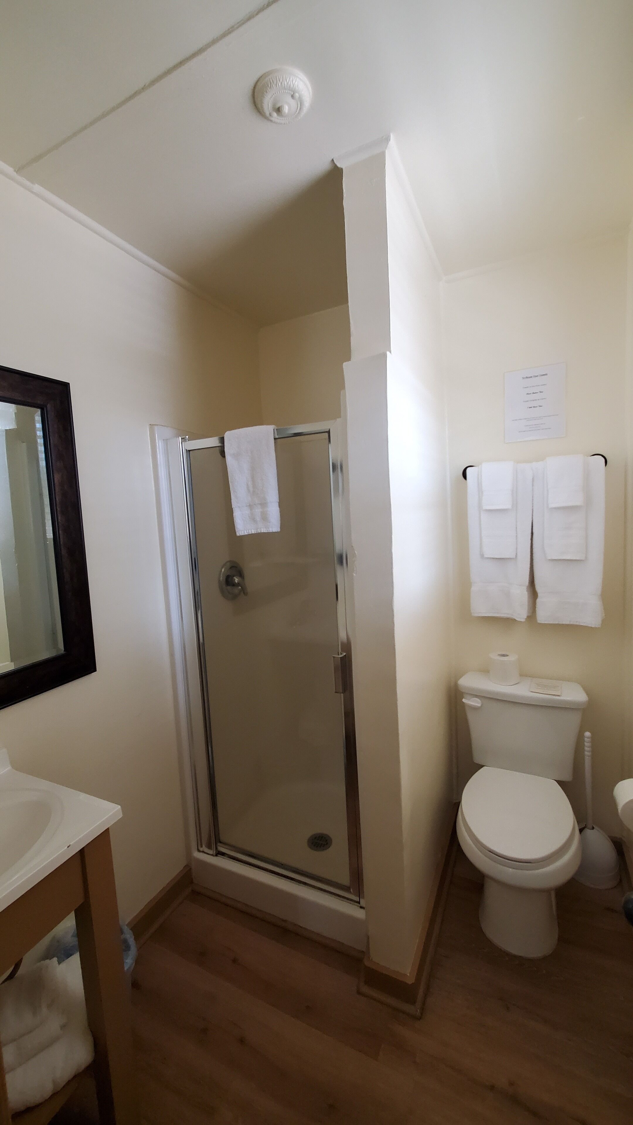 Une salle de bain avec une douche à parois de verre, des toilettes et un lavabo.