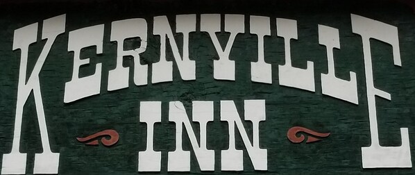 Letrero del Kernyville Inn con letras blancas grandes sobre un fondo oscuro.