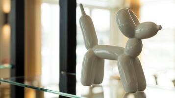 A glass table with a white, abstract sculpture resembling a dog.