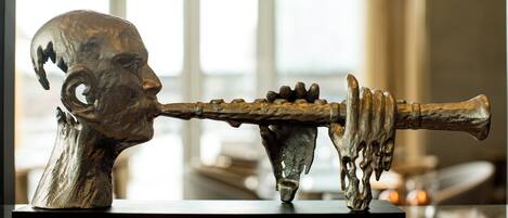 Una escultura de una cabeza y un cuerno sobre una estantería.