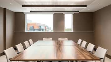 A conference room with a long table, chairs, and large windows.