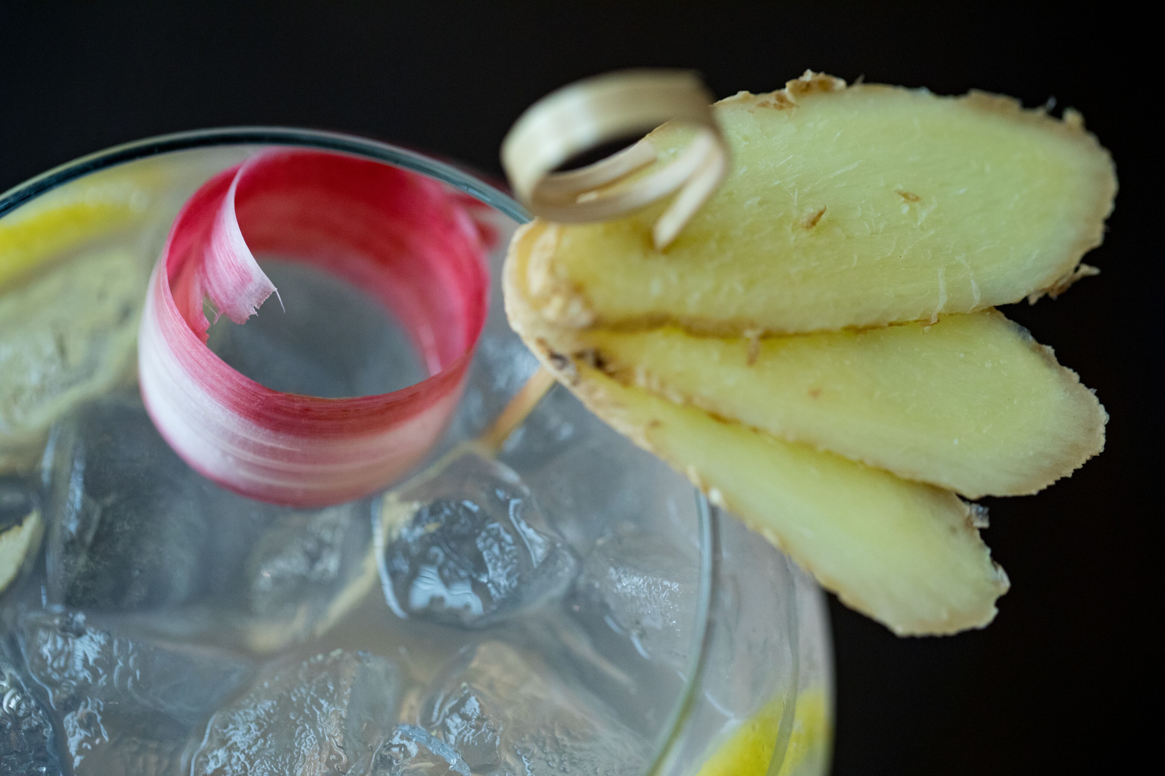 Un vaso con cubitos de hielo y una rodaja de piña en un palito.