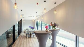 A modern interior with a dining area, large windows, and pendant lighting.