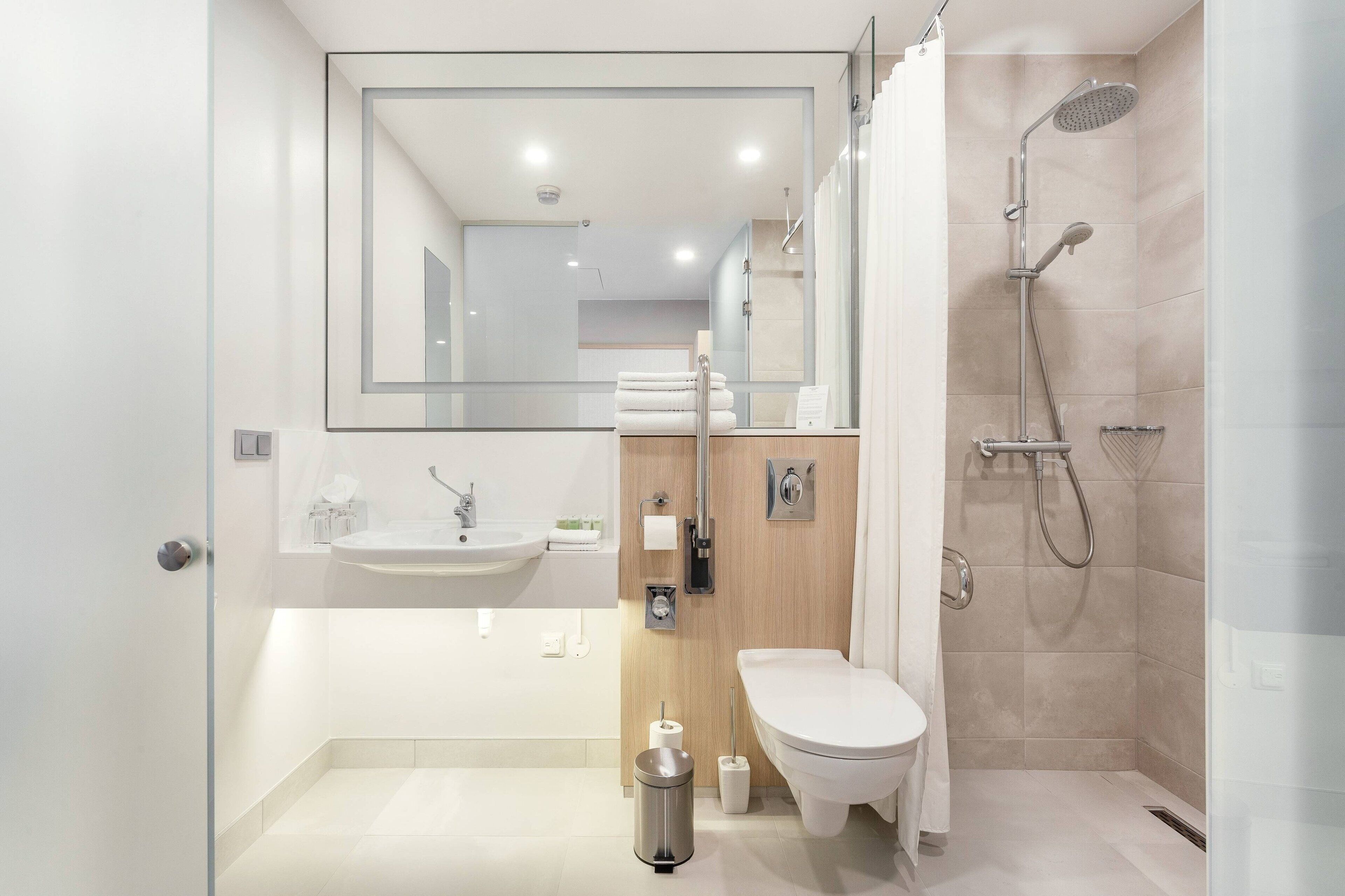 A modern bathroom with a sink, toilet, and shower.