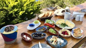 A table set with various dishes and a view of the sea. - Deep Ocean Camping - Adults Only (Fethiye)