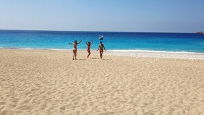 A sandy beach with three people playing near the water. - Deep Ocean Camping - Adults Only (Fethiye)