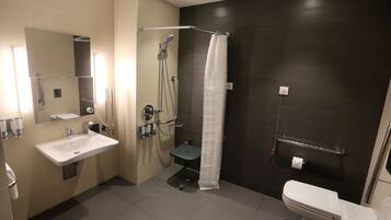 Een moderne badkamer met een wastafel, toilet en douche.