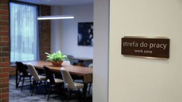 Een vergaderruimte met een bord waarop staat: 'strefa do pracy work zone'.