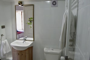 Apartamento standard | Banheiro | Chuveiro, produtos de toalete grátis, secador de cabelo