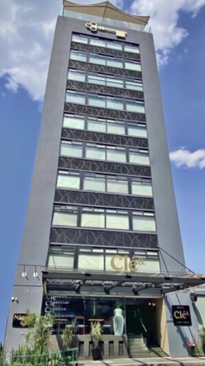 A tall, modern building with a key symbol on the top. - Hotel Cle Reforma Insurgentes (Mexico City)