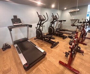 A gym with various exercise equipment including treadmills, stationary bikes, and a rowing machine. - Hotel Cle Reforma Insurgentes (Mexico City)