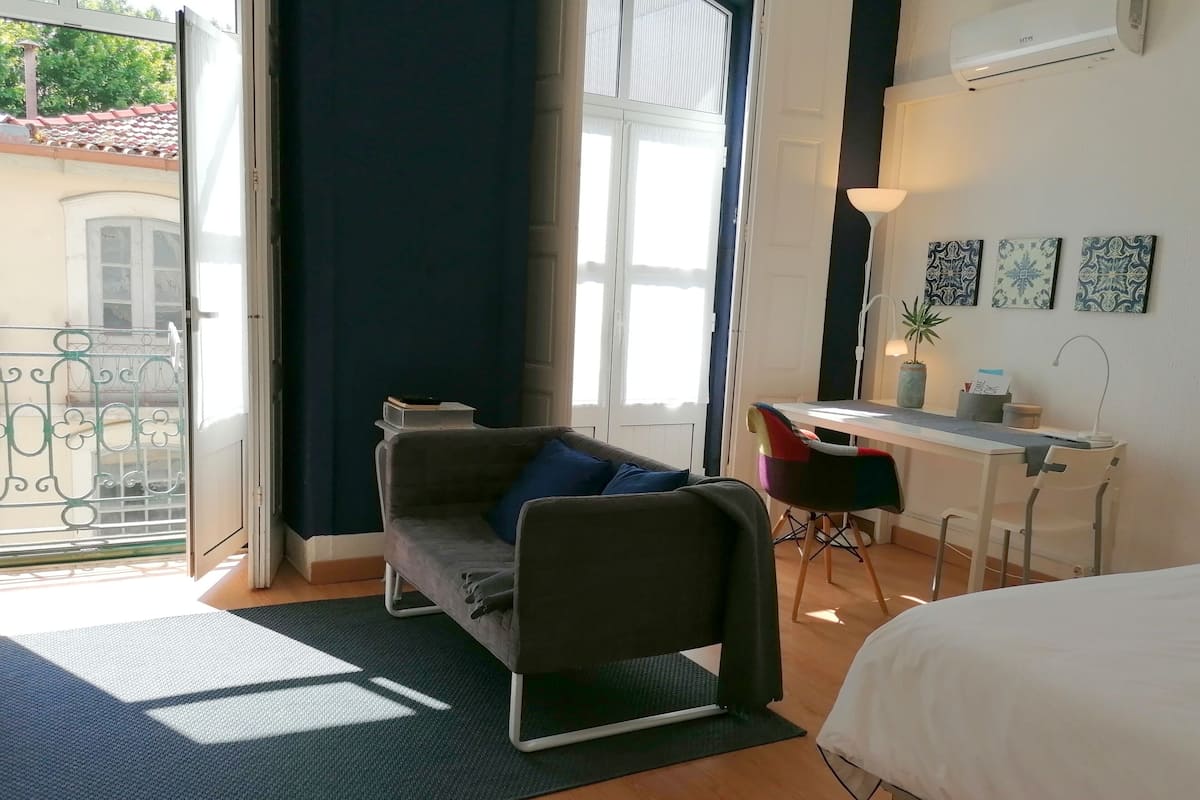 A modern room with a bed, a desk, and a sofa.