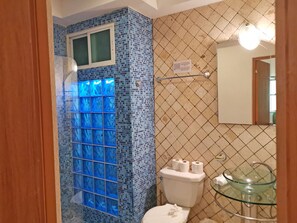 A bathroom with a tiled wall, a glass shower enclosure, a toilet, and a glass sink. - Las Olas 206 by PRP (Playa del Carmen)