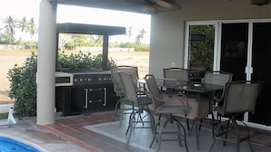 An outdoor patio with a grill, dining table, and chairs. - Casa Lin (Mazatlán)