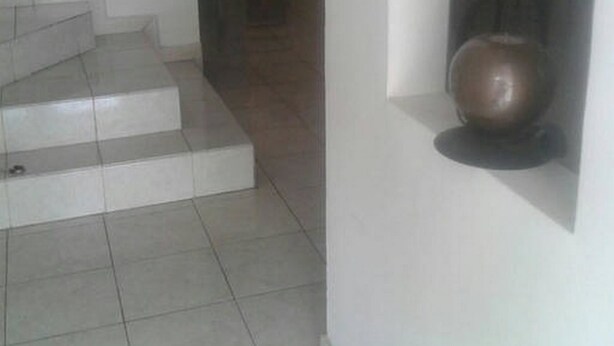 A staircase leading to a landing with a wall-mounted exercise equipment. - Casa Lupita (Mazatlán)